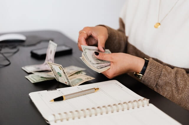 crop-payroll-clerk-counting-money-while-sitting-at-table